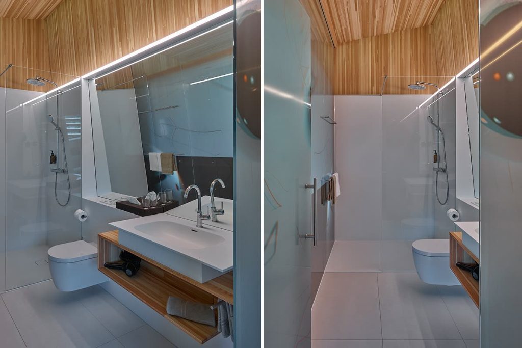 Badezimmer mit Holzdecke, Waschtisch auf offenem Holzregal und Duschbereich hinter Glas