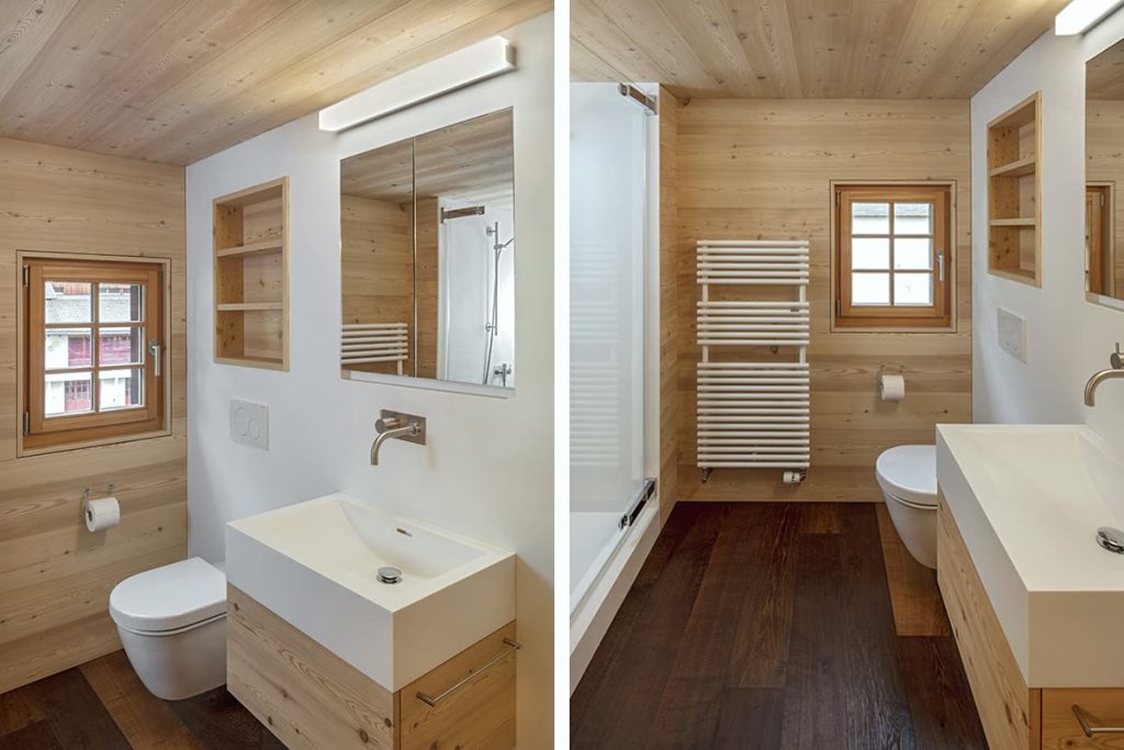 Badezimmer mit heller Holzverkleidung, Holzdecke, Nische und weissem Waschtisch auf Holzunterbau