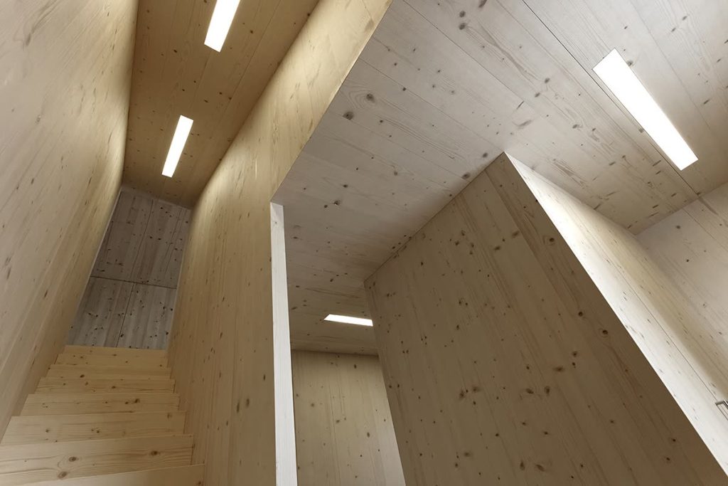 Treppenhaus mit Wänden aus hellem Massivholz und eingelassenen Lichtbändern