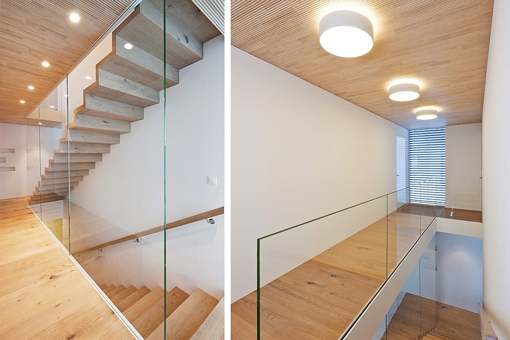 Treppe mit Glasbrüstung und Holzlamellendecke, helle Eichenböden im Treppenhaus