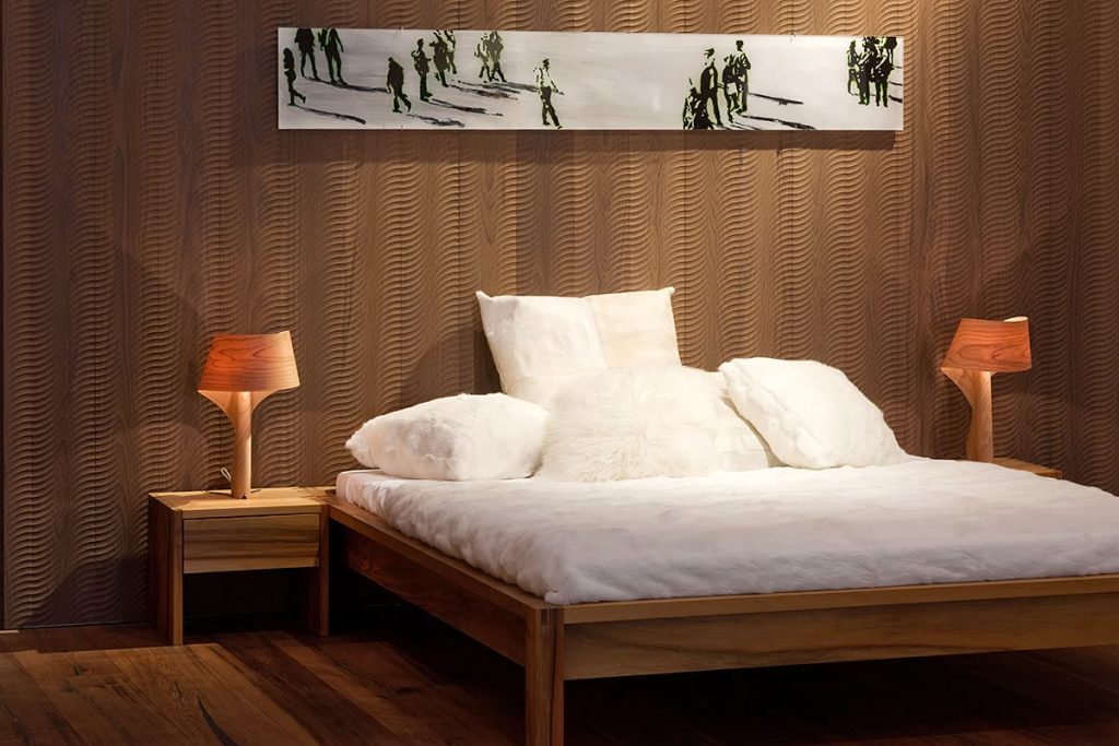 Bett aus Nussbaum mit Nachttischen, Wandverkleidung in Holz und Lampen