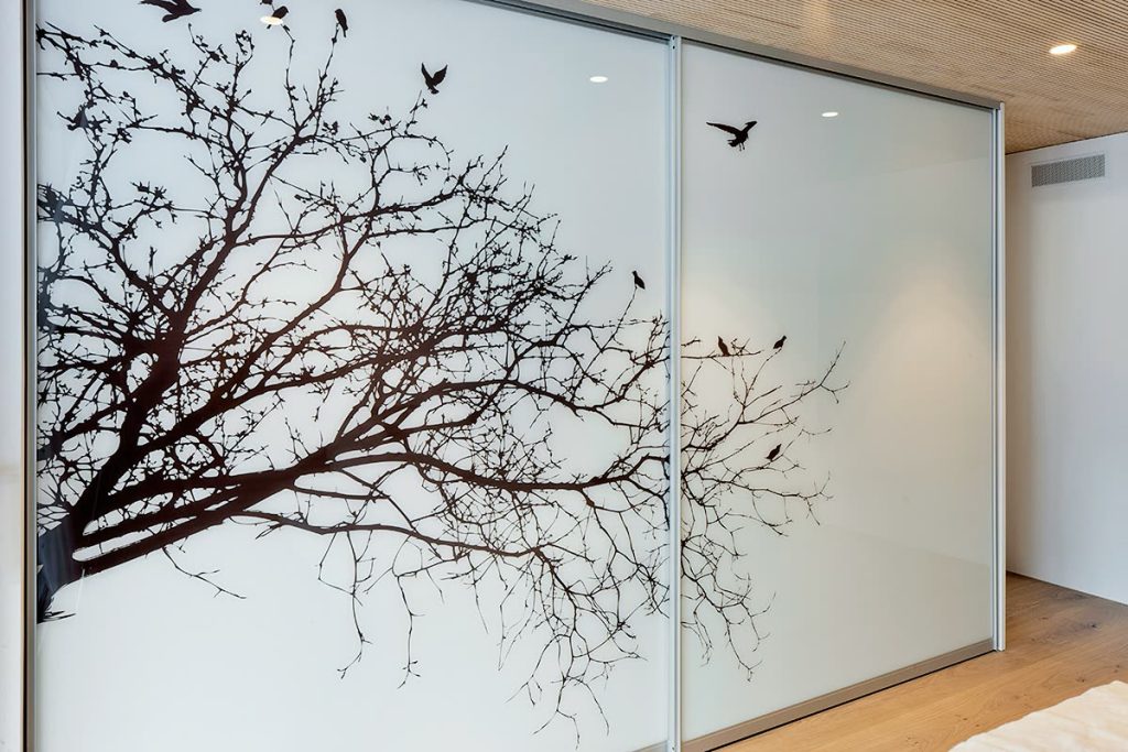 Schiebetür-Einbauschrank mit Weissglas, Baummotiv und Aluminiumrahmen – Zeiter + Berchtold, Brig-Glis