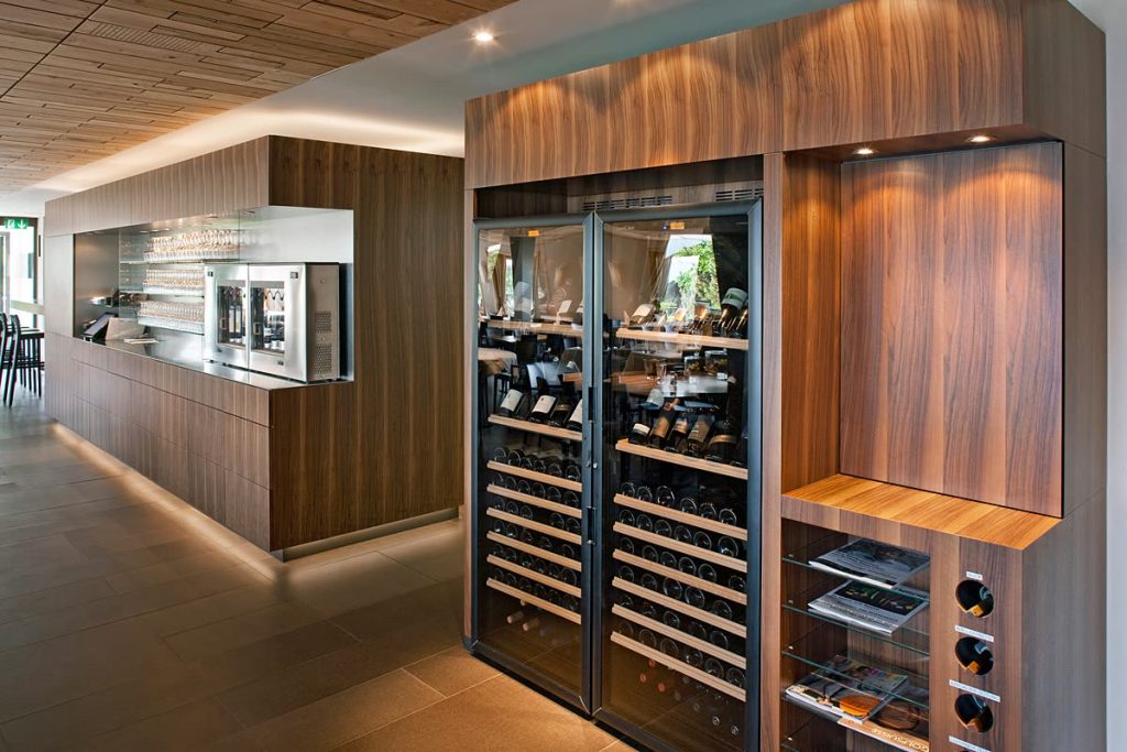 Weinklimaschrank mit Nussbaum-Verkleidung und Einbauregal im Restaurant